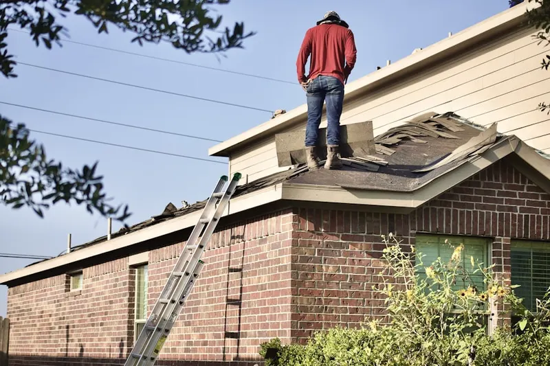 Professional roofer working on a residential roof in Gaines